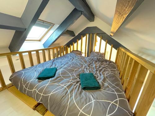 a bedroom with a bed with green pillows on it at Escapade Morétaine - Le Loft in Moret-sur-Loing