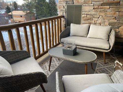 a patio with two chairs and a table and a couch at Silver Rock Condominiums by Fernie Central Reservations in Fernie