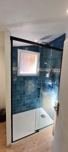 a shower in a bathroom with a blue tiled wall at Casa Ismaia Studio avec piscine au calme in Montauroux