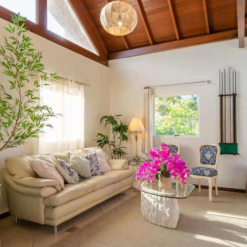 a living room with a couch and a table with flowers at Penareia Floripa Beach Hotel in Florianópolis