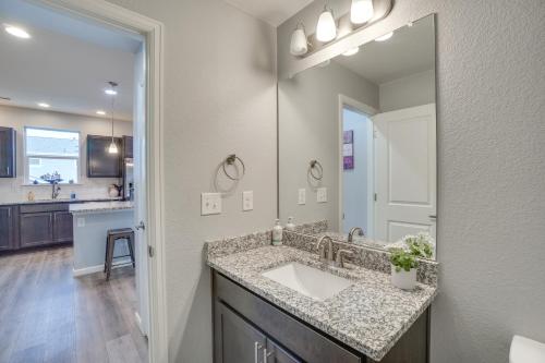 a bathroom with a sink and a large mirror at Suburban Denver Home with Fire Pit and Shuffleboard! in Denver