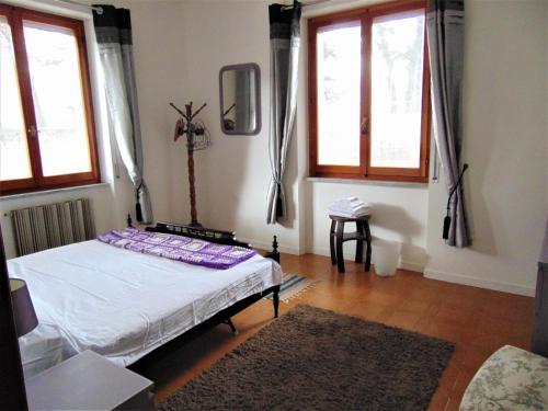 1 dormitorio con 1 cama en una habitación con ventanas en Casa Appenninia, en Albareto