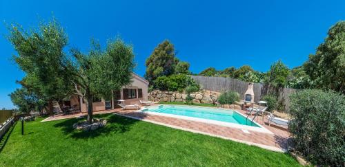 a backyard with a swimming pool and a yard with green grass at Villa Ara in Torre delle Stelle