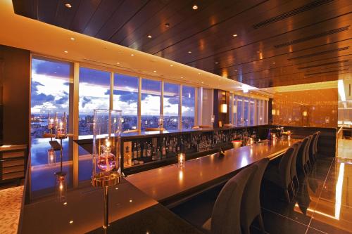a restaurant with a long bar with a view at Rihga Royal Gran Okinawa in Naha