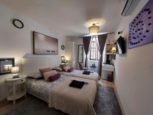 sypialnia z 2 łóżkami i kanapą w obiekcie Apartment Agora w mieście Zadar