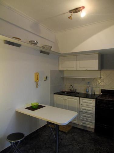 cocina con armarios blancos y encimera blanca en Departamento excelente ubicación en La Plata