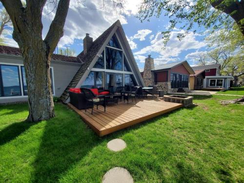 a backyard with a wooden deck and a house at Sandy Beach Retreat on Big Spirit Lake in Spirit Lake
