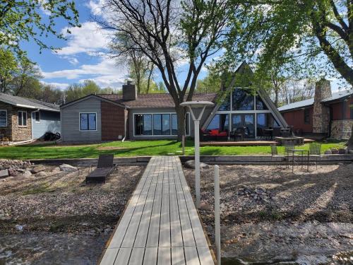 a house with a wooden walkway in front of a house at Sandy Beach Retreat on Big Spirit Lake in Spirit Lake