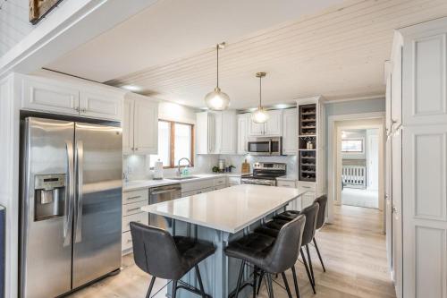 une cuisine avec un grand îlot de cuisine et des chaises noires dans l'établissement Sandy Feet Retreat on Big Spirit Lake, à Spirit Lake