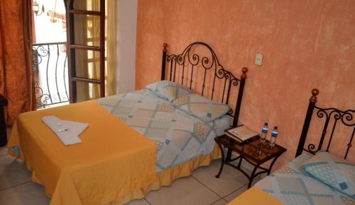 um quarto com uma cama, uma mesa e uma janela em Hotel Villa Florencia Centro Histórico em San Salvador