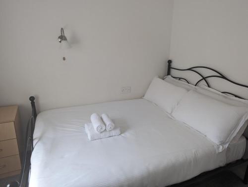 a white bed with two towels on top of it at Bridge Terrace E in Southampton