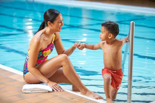 a woman sitting next to a boy in a pool at Holiday Inn - Chicago Dwtn - The Mart by IHG in Chicago