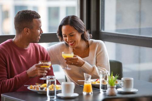 Un hombre y una mujer sentados en una mesa bebiendo jugo de naranja en Holiday Inn - Chicago Dwtn - The Mart by IHG, en Chicago