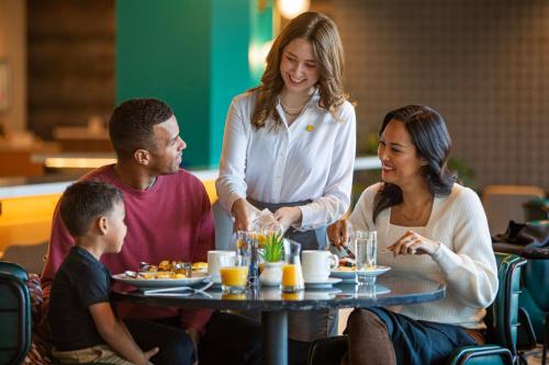 Un grupo de personas sentadas alrededor de una mesa en un restaurante. en Holiday Inn - Chicago Dwtn - The Mart by IHG, en Chicago