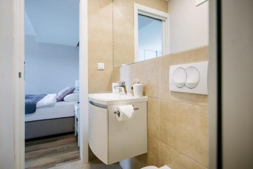 a small bathroom with a sink and a bed at SEA PEARL APARTMENTS by DuHomes in Dubrovnik