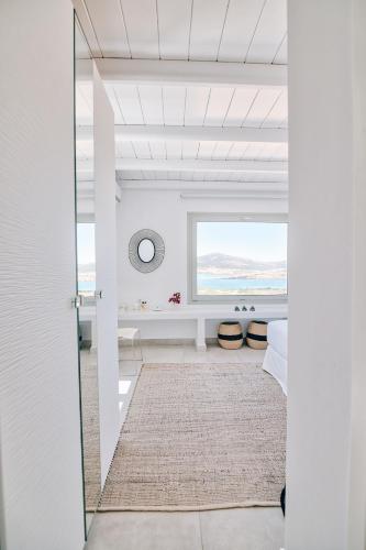 a bedroom with a view of the ocean through a glass door at Antiparos Thea in Antiparos