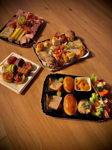 trois plaques alimentaires sur une table en bois dans l'établissement Love room avec jacuzzi privé, à Bonnétable