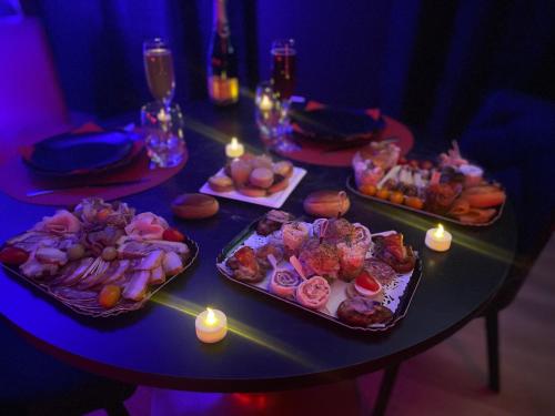 a table with three trays of food on it at Love room avec jacuzzi privé in Bonnétable