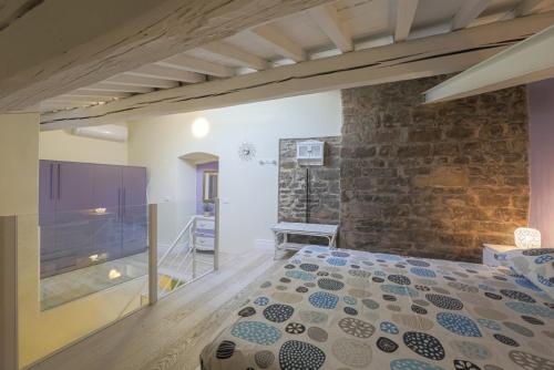 a bedroom with a bed and a stone wall at Margarida Apartment in Florence