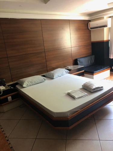 Cama grande en habitación con paredes de madera en Hotel Serrano en Río de Janeiro