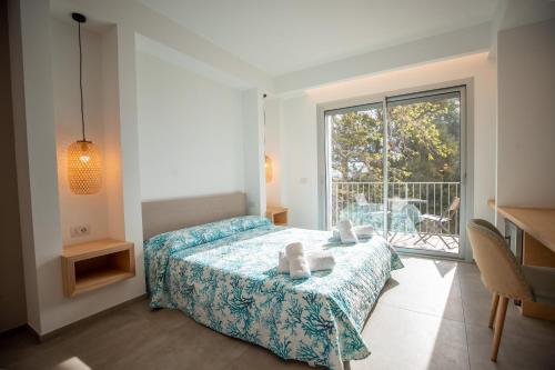 a bedroom with a bed and a large window at Molo Brin Rooms & Suites in Olbia