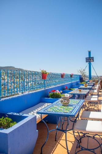 a row of tables and chairs on a roof at VANCII Hotel in Chefchaouene