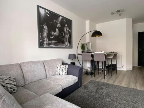 a living room with a couch and a dining table at Modern 1 bedroom flat with patio garden & parking in Ashford