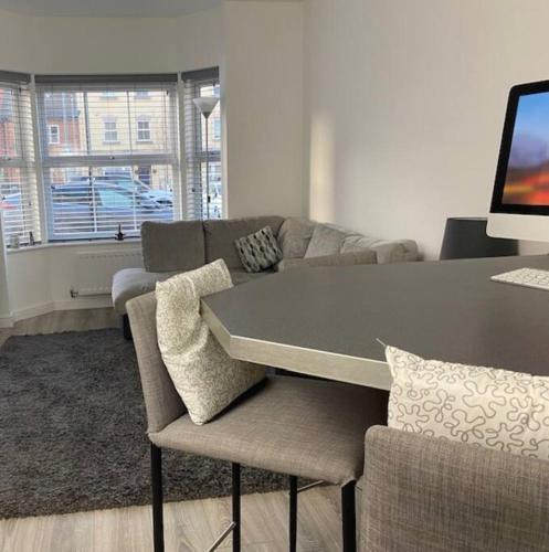 a living room with a table and a couch at Modern 1 bedroom flat with patio garden & parking in Ashford