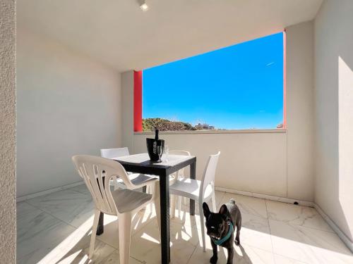 a dog standing next to a table and chairs at Zeus in Bibione