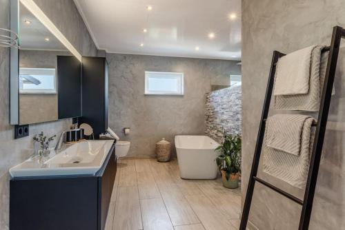 a bathroom with a sink and a bath tub at Modern Oasis HotTub, View, Gym in Oberbettingen
