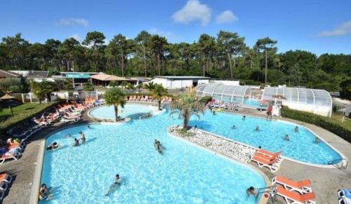 - une grande piscine dans un complexe avec des personnes dans l'établissement Mobil home camping luxe 4 étoiles, à Lège-Cap-Ferret