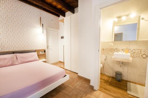 1 dormitorio con cama blanca y lavamanos en Avenida 12 en Alghero
