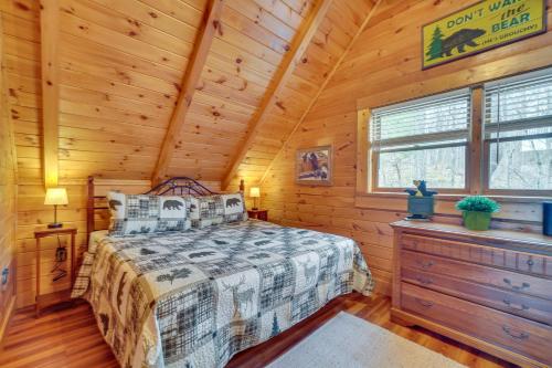 a bedroom with a bed in a log cabin at Gatlinburg Cabin Hot Tub and Loft with Games! in Gatlinburg