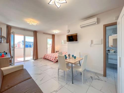 a living room with a table and chairs and a bedroom at Zeus in Bibione