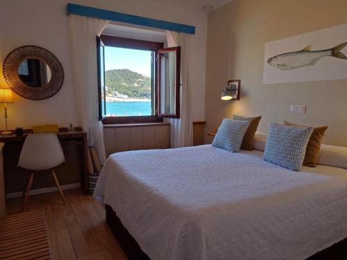 sypialnia z łóżkiem i widokiem na ocean w obiekcie Hotel Cap d'Or w Tossa de Mar