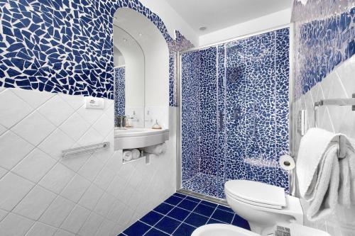 a blue bathroom with a toilet and a shower at BlueVista Dreamscape Home -Terrace Jacuzzi/Hot Tub in Positano