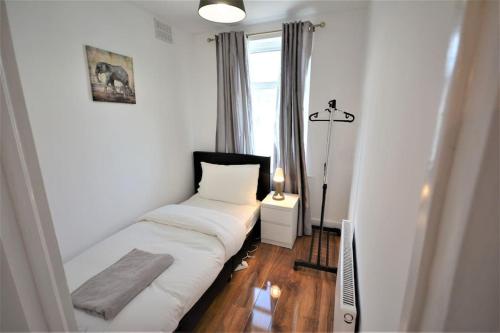 een kamer met een bed in een kamer met een raam bij 4 Bedroom House in East London in Londen