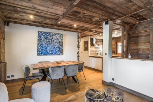 a dining room with a wooden table and chairs at Exceptional flat in a chalet - Megève - Welkeys in Megève