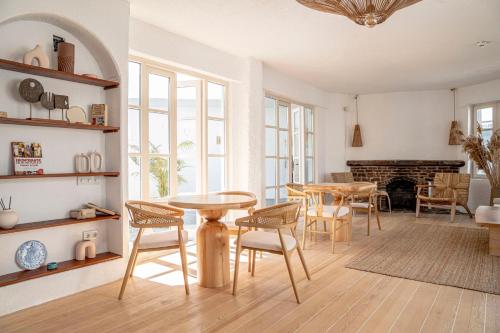 a living room with tables and chairs and a fireplace at Kurabiye Hotel in Alacati