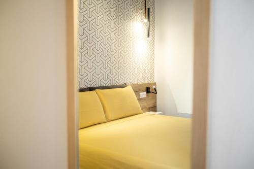 a bedroom with a yellow bed and a wall at Avenida 12 in Alghero