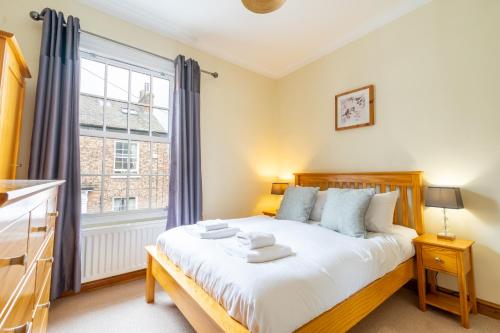 a bedroom with a bed and a large window at 7 Buckingham Street in York