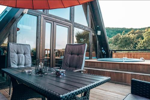 a table and chairs on a balcony with a tub at Valdo Cabin in Sadu