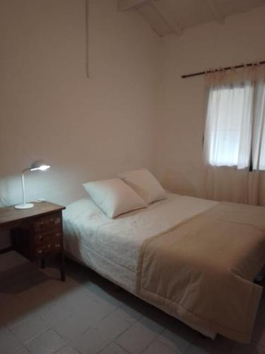 een slaapkamer met een bed, een tafel en een raam bij luna creciente in Tandil