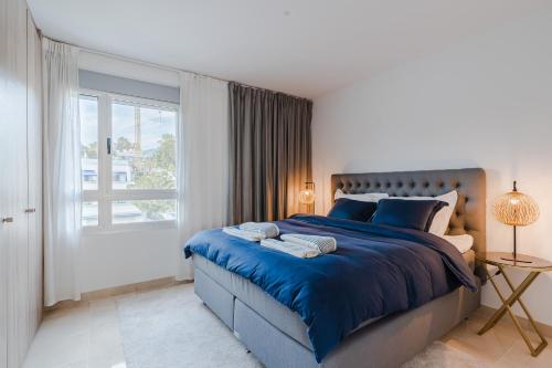 Un dormitorio con una cama azul y una ventana en Penthouse - Royal Banus, en Marbella