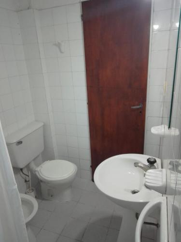 een witte badkamer met een toilet en een wastafel bij luna creciente in Tandil