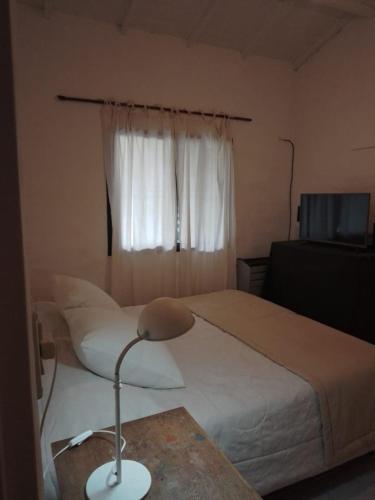 een slaapkamer met een bed en een bureau met een lamp bij luna creciente in Tandil