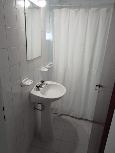 een witte badkamer met een wastafel en een douche bij luna creciente in Tandil