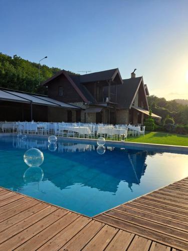 a swimming pool with white chairs and a house at Villa Tuman Loutra Pozar Aridaias in Aridaia