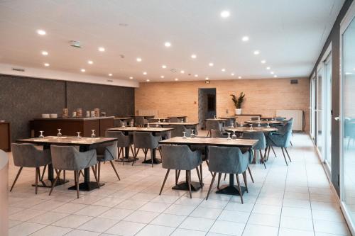 a restaurant with tables and chairs in a room at HOTEL DU MOULIN in Voué