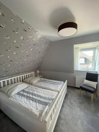 - une chambre avec un lit avec des oiseaux sur le mur dans l'établissement Haus-Seeschwalbe-Wohnung-2, à Nieblum